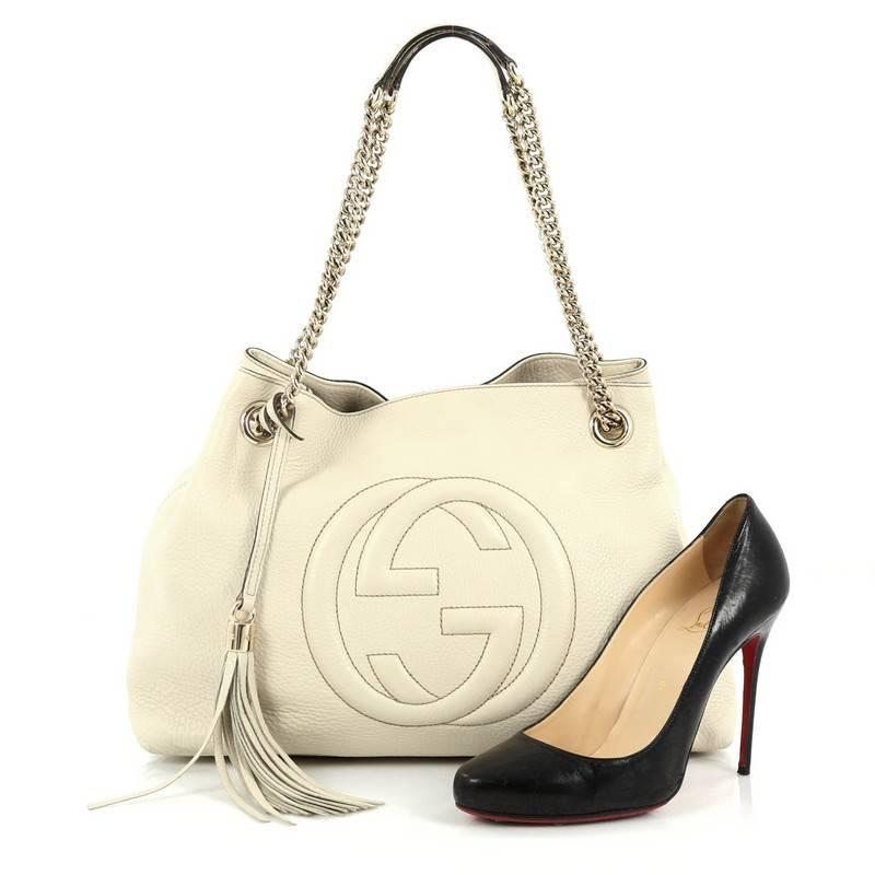This authentic Gucci Soho Shoulder Bag Chain Strap Leather Medium is simple yet stylish in design. Crafted from off-white leather, this hobo features gold chain strap with leather pads, fringe tassel, signature interlocking Gucci logo stitched in