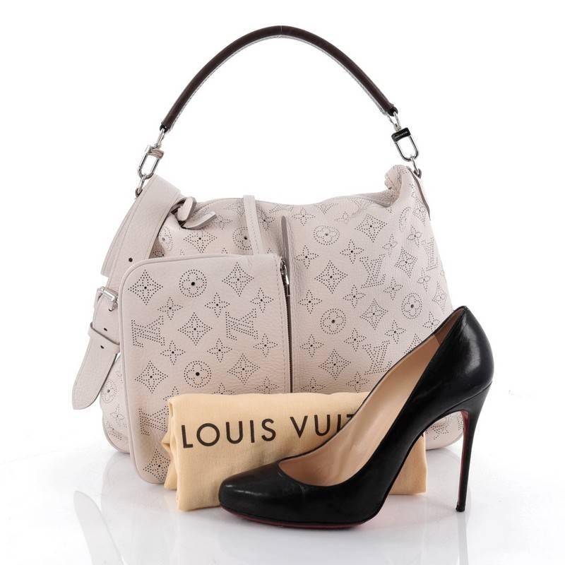 This authentic Louis Vuitton Selene Handbag Mahina Leather PM showcased in the brand's Spring/Summer 2013 collection is a luxe, feminine design. Crafted in light taupe monogram perforated mahina leather, this beautiful hobo features a single loop