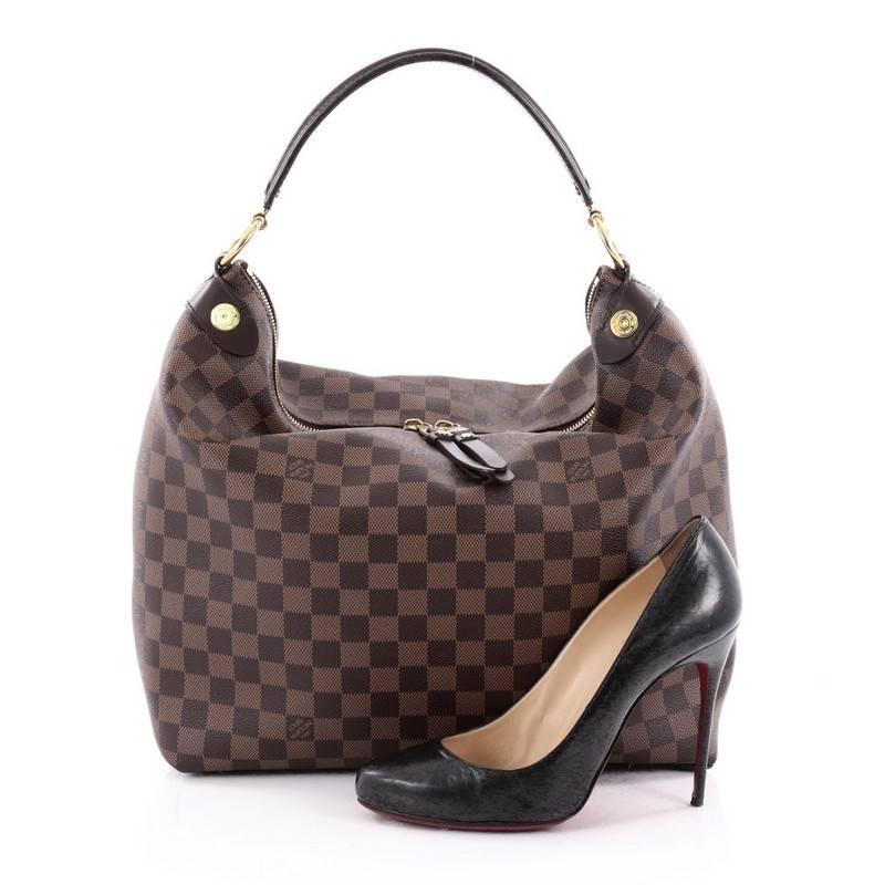 This authentic Louis Vuitton Duomo Hobo Damier exemplifies understated luxury made for the modern woman. Crafted from damier ebene coated canvas this refined, city hobo features a looped polished dark brown top handle, stamped metal rivets, leather