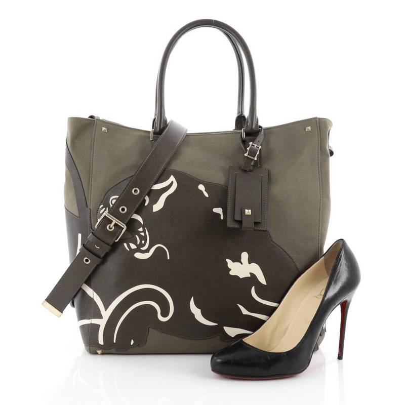 This authentic Valentino Panther Tote Canvas with Leather is minimalist yet functional perfect for everyday work. Crafted in khaki green canvas, this tote features dual-rolled leather handles, adjustable and removable leather strap, stitched brown