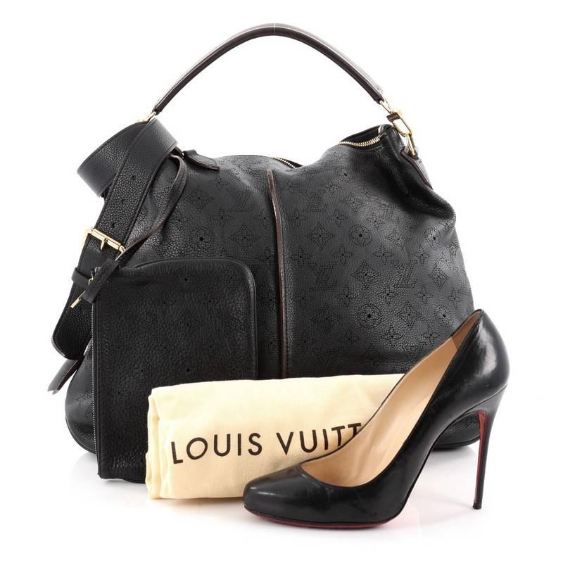 This authentic Louis Vuitton Selene Handbag Mahina Leather MM showcased in the brand's Spring/Summer 2013 collection is a luxe, feminine design. Crafted from black monogram perforated mahina leather, this beautiful hobo features an adjustable
