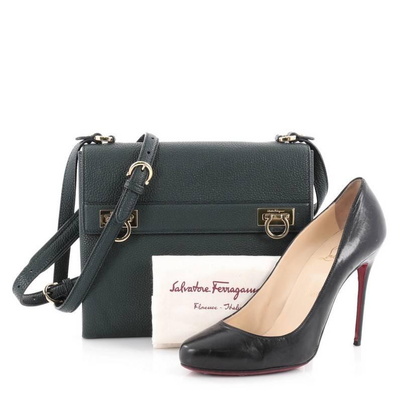 This authentic Salvatore Ferragamo Mya Double Lock Crossbody Bag Pebbled Leather is perfect for woman on-the-go. Crafted from dark green pebble leather, this bag features adjustable shoulder strap, flap top with two Gancini flip locks, exterior back