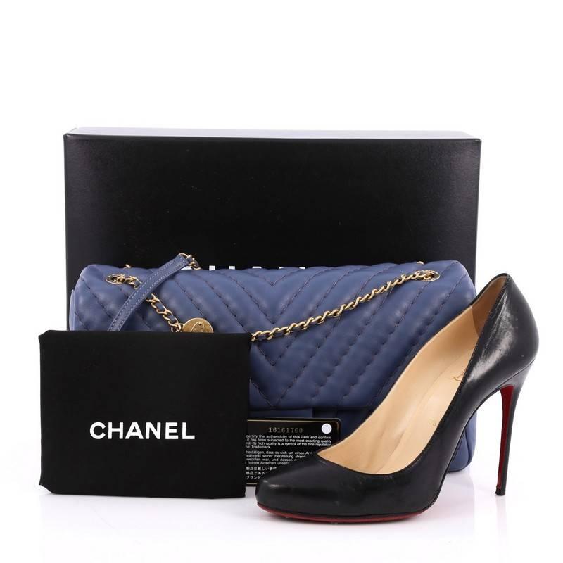 This authentic Chanel Medallion Charm Flap Bag Chevron Calfskin Jumbo presented in the brand's Cruise 2013-2014 Collection mixes feminine luxurious with casual youthfulness made for the modern woman. Crafted in luxurious blue calfskin, this feminine