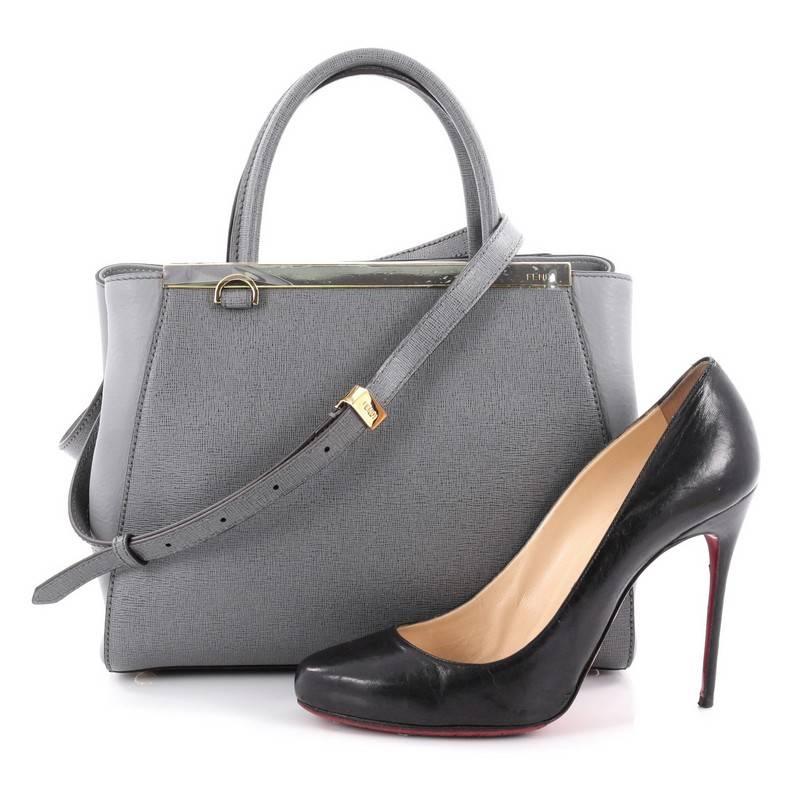 This authentic Fendi 2Jours Handbag Leather Petite is impeccably stylish with its simple silhouette. Crafted from grey leather, this chic tote features dual-rolled leather handles, a shining top bar with the Fendi brand name, protective base studs,