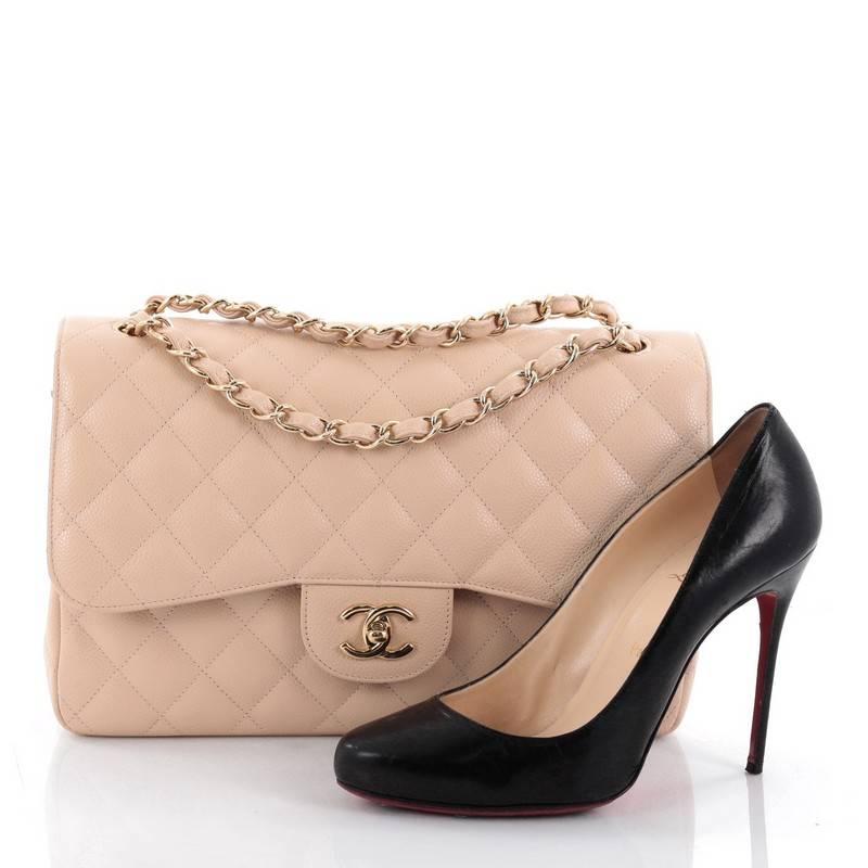 This authentic Chanel Classic Double Flap Bag Quilted Caviar Jumbo is one of the brand's most popular styles. Crafted from nude caviar leather, this elegant flap features Chanel's signature diamond quilted design, woven-in leather chain straps,