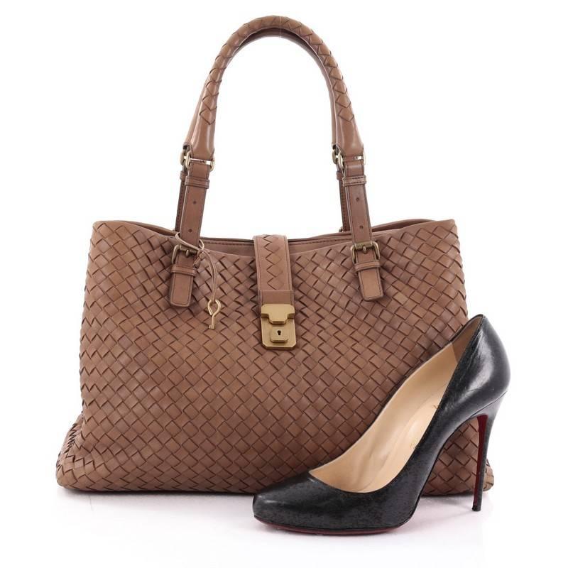 This authentic Bottega Veneta Roma Handbag Intrecciato Nappa Medium is a finely crafted tote that exudes an understated elegance. Crafted from brown nappa leather woven in Bottega Veneta's signature intrecciato method, it features dual woven leather