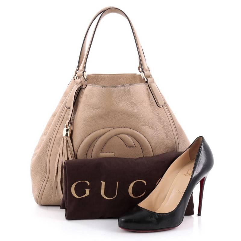 This authentic Gucci Soho Shoulder Bag Leather Medium is simple yet stylish in design. Crafted in beige leather, this hobo features dual-flat leather handles, fringe tassel, protective base studs, signature interlocking Gucci logo stitched in front