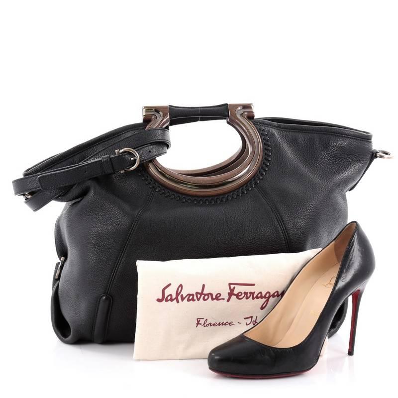 This authentic Salvatore Ferragamo Fiammetta Tote Whipstitch Leather is exquisite in its structure and design. Crafted in black leather with whipstitch detailing, this luxurious bag features the brand's signature Gancini-styled top handle, folded