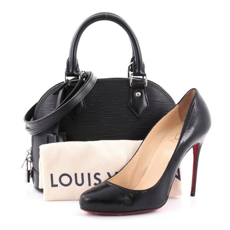 This authentic Louis Vuitton Alma Handbag Epi Leather BB is a chic and sophisticated bag perfect for your everyday use. Constructed with Louis Vuitton's signature sturdy black epi leather, this petite dome-like bag features a sturdy base, protective