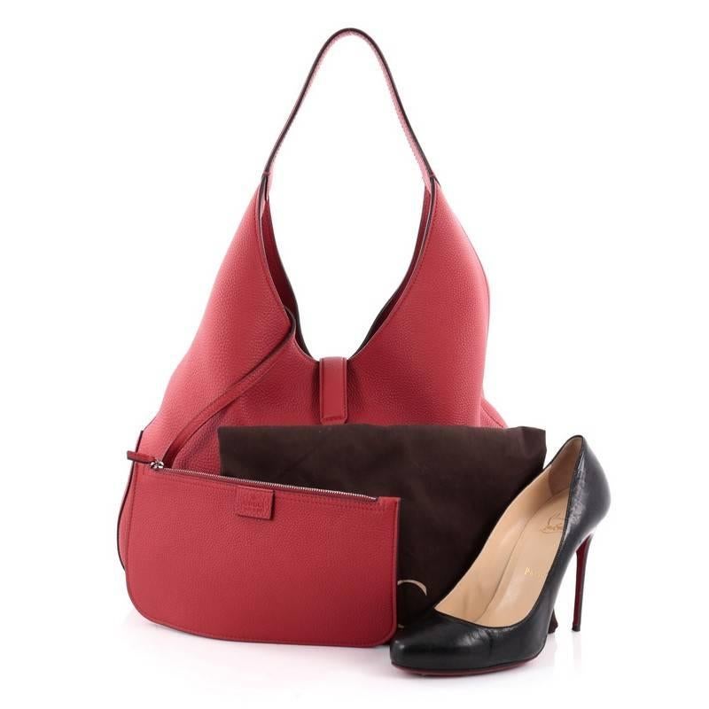 This authentic Gucci Jackie Hobo Soft Leather presented in the brand's Fall/Winter 2014 Collection is a modern and clean representation of its classic Jackie bag. Crafted from red soft leather, this luxurious, no-fuss hobo features a single loop