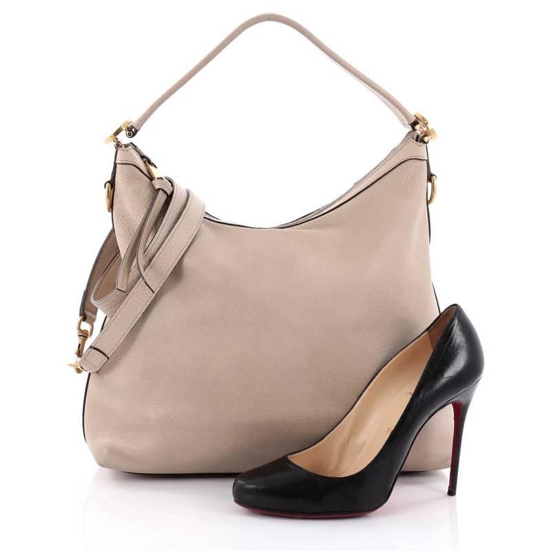 This authentic Gucci Miss GG Hobo Leather Small is a timeless and elegant hobo made for everyday use. Crafted from beige leather, this hobo features a flat leather shoulder strap, signature interlocking GG hardware on the side and gold-tone hardware