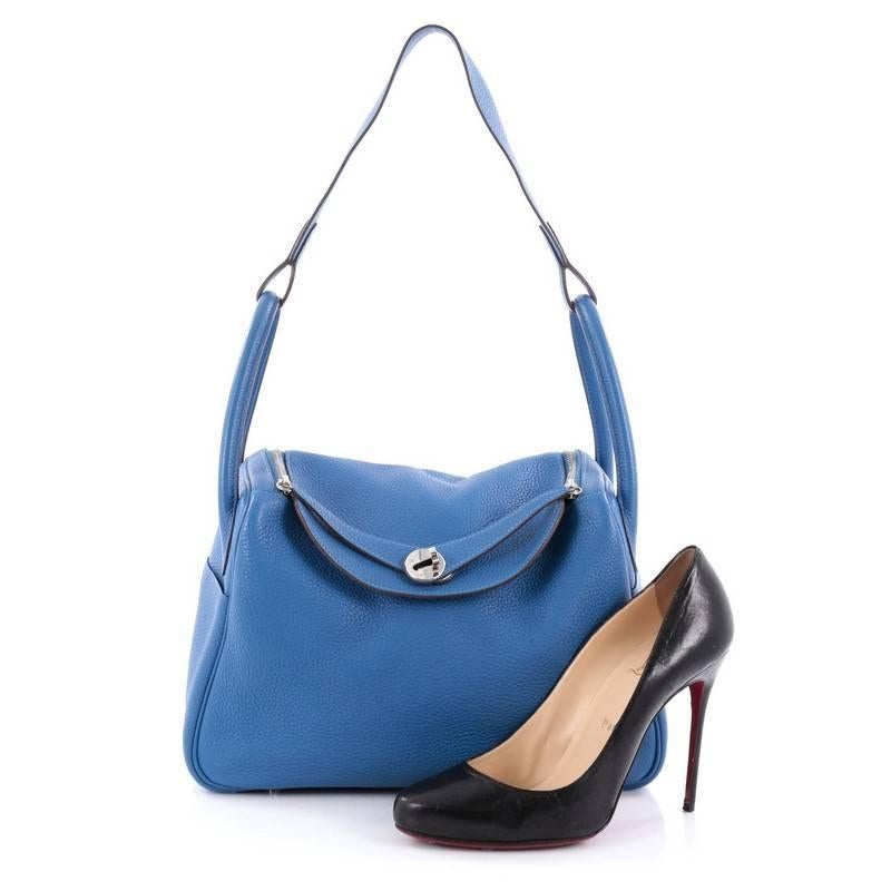 This authentic Hermes Lindy Handbag Clemence 30 is the perfect understated accessory for the modern woman. Crafted from blue electric clemence leather, this no-fuss shoulder bag features dual rolled handles, two sides slip pockets, protective base