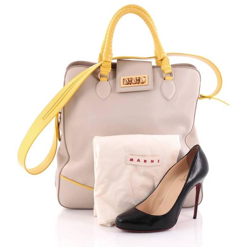 This authentic Christian Louboutin Padam Shopping Tote Leather Medium is the newest Loubi Lover must-have! Crafted from light gray leather with yellow leather trims, this bag features dual-rolled woven leather handles, detachable strap, gold-tone