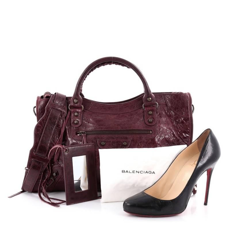 This authentic Balenciaga City Classic Studs Handbag Leather Medium is for the on-the-go fashionista. Constructed in burgundy leather, this popular bag features dual braided woven handle straps, front zip pocket, iconic Balenciaga classic studs and