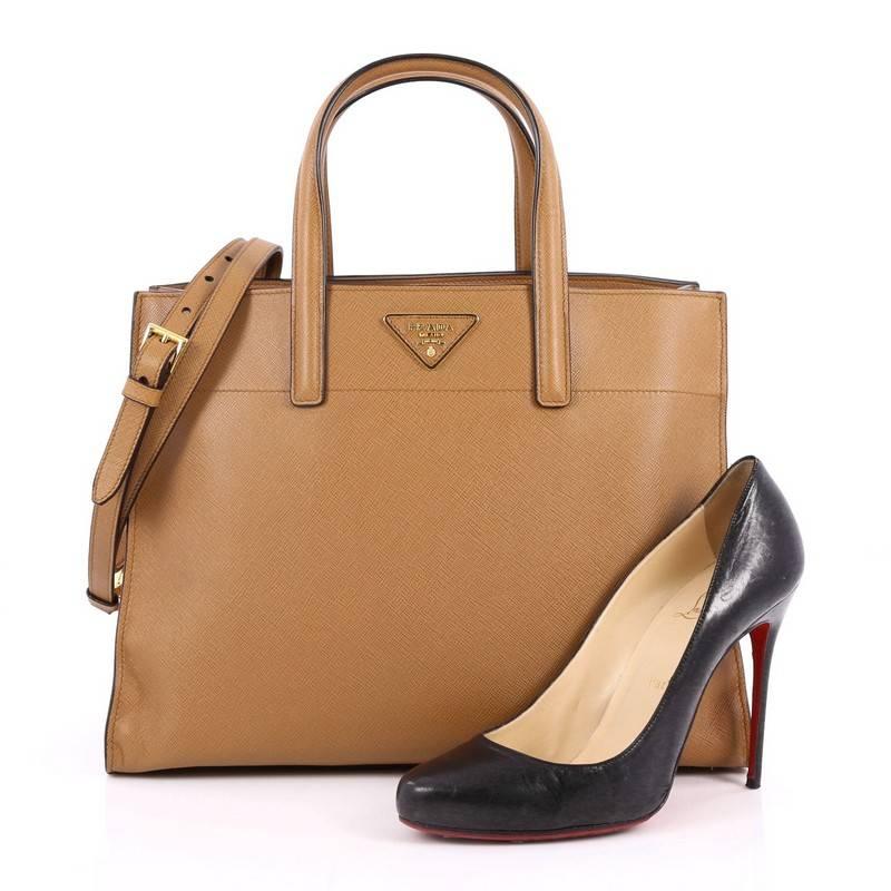 This authentic Prada Soft Triple Pocket Convertible Tote Saffiano Leather is elegant in its simplicity and structure. Crafted in light brown saffiano leather, this stylish yet functional tote features dual flat handles, signature raised Prada logo