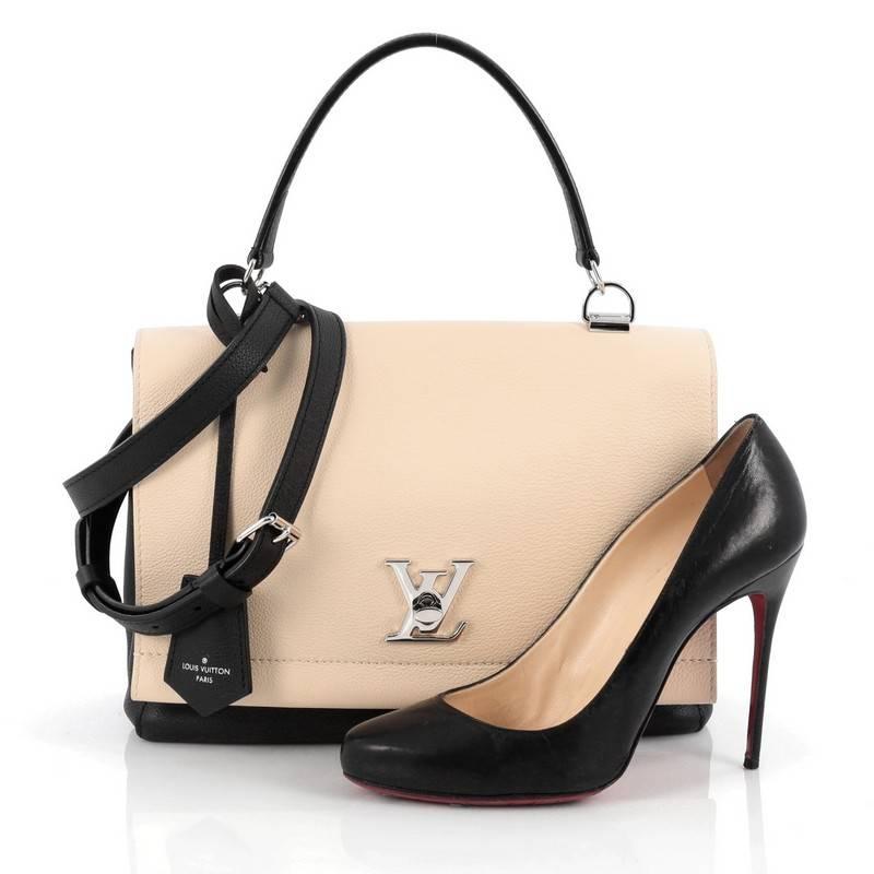 This authentic Louis Vuitton Lockme II Bag Leather presented in the brand's 2015 Collection is a must-have signature, city bag made for the modern woman. Crafted from beige and black leather, this chic bag features an adjustable removable shoulder