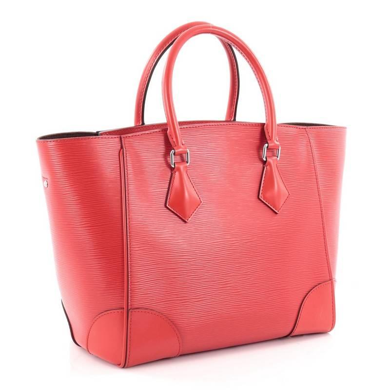 This authentic Louis Vuitton Phenix Tote Epi Leather MM combines graphic, modern lines with chic details. Crafted from red epi leather, this chic bag features dual-rolled leather handles, detachable strap, smooth leather trims and corners,