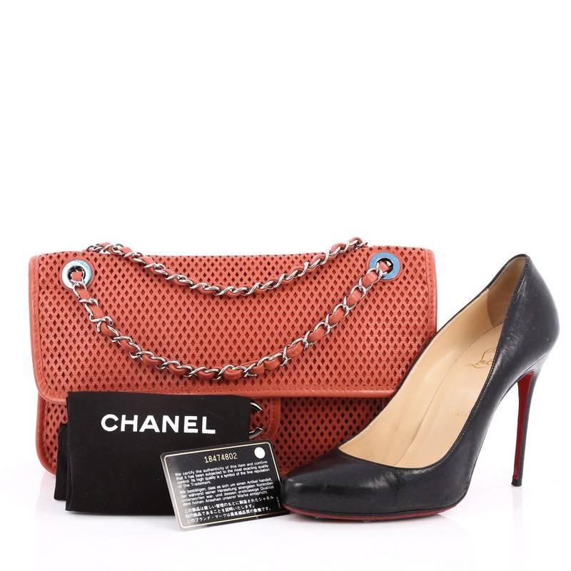 This authentic Chanel Up In The Air Flap Bag Perforated Leather Medium presented in the brand's Pre-Spring and Summer 2013 Collection showcases a sporty-chic update to Chanel's beloved classic flaps. Crafted in lightweight coral perforated leather,