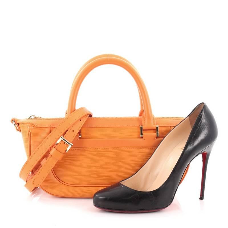 This authentic Louis Vuitton Dhanura Handbag Epi Leather PM is the perfect bag to add a pop of color to all daily or evening outfits. Constructed in sturdy light orange epi leather, this bag features a unique boat-like silhouette, dual-rolled