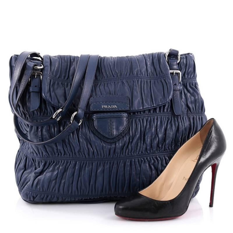 This authentic Prada Buckle Strap Shoulder Bag Nappa Gaufre Large is perfect for everyday use. Crafted in blue nappa gaufre leather, this shoulder bag features dual buckle leather straps, frontal flap, protective base studs and silver-tone hardware