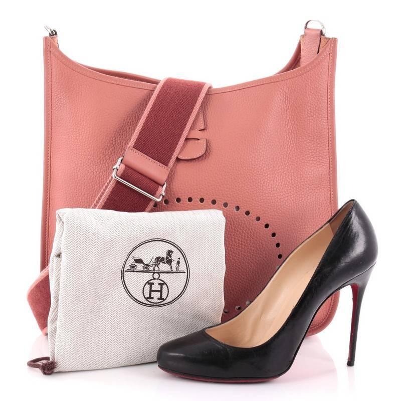 This authentic Hermes Evelyne Crossbody Gen III Clemence PM showcases a simple, day-to-day style perfect for someone's first Hermes bag. Crafted from rose tea pink clemence leather, this crossbody bag features a signature perforated H design at the