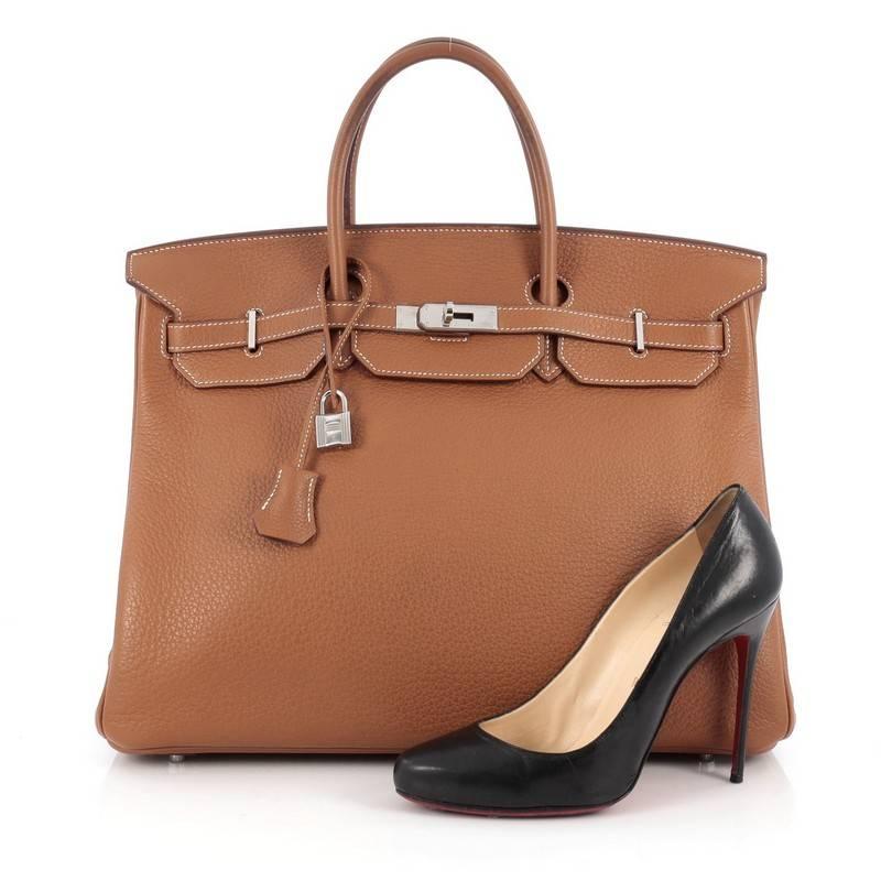 This authentic Hermes Birkin Handbag Gold Clemence with Palladium Hardware 40 showcases subtle elegance. Finely crafted in beautiful, scratch-resistant gold clemence leather, this piece features dual-rolled top handles, frontal flap, turn-lock