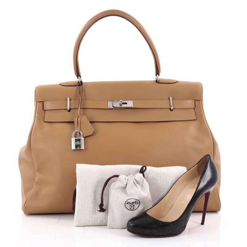 This authentic Hermes Kelly Relax Handbag Biscuit Swift with Palladium Hardware 50 showcases a reinterpretation of the classic Kelly design made for sophisticated traveling for any fashionista. Designed from sleek biscuit brown scratch resistant