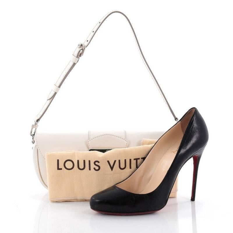 This authentic Louis Vuitton Montaigne Clutch Epi Leather is an exquisite piece that is perfect for day-to-night. Crafted from off-white epi leather, this clutch features subtle LV logo, adjustable and removable flat leather shoulder strap and