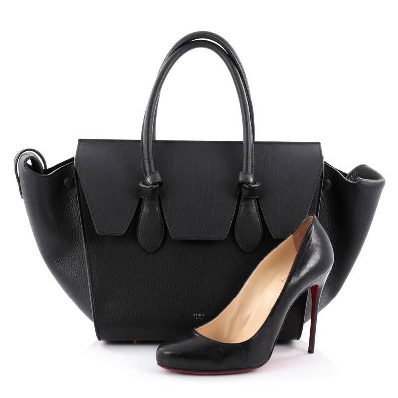 This authentic Celine Tie Knot Tote Grainy Leather Mini is an absolute must-have for serious fashionistas. Crafted from black grainy leather, this boxy, chic tote features dual-rolled leather handles with signature knot accents, subtle stamped gold