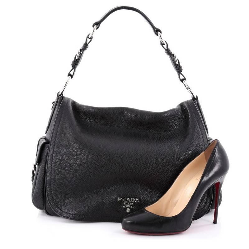 This authentic Prada Side Pocket Flap Shoulder Bag Vitello Daino Large is a stylish and sophisticated everyday bag made for the modern woman. Crafted from black pebbled leather, this bag features flat leather shoulder strap with buckle details,