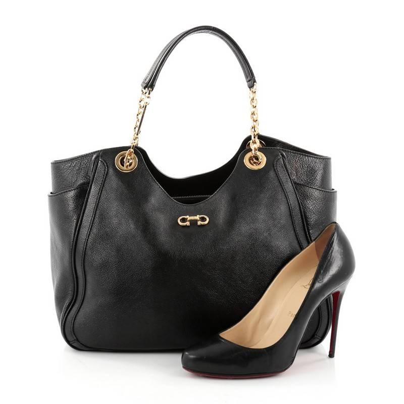 This authentic Salvatore Ferragamo Betulla Chain Tote Leather Medium is minimalist and classic in design, ideal for everyday use. Crafted from black leather, this elegant tote features chain shoulder straps with leather pads, signature Salvatore