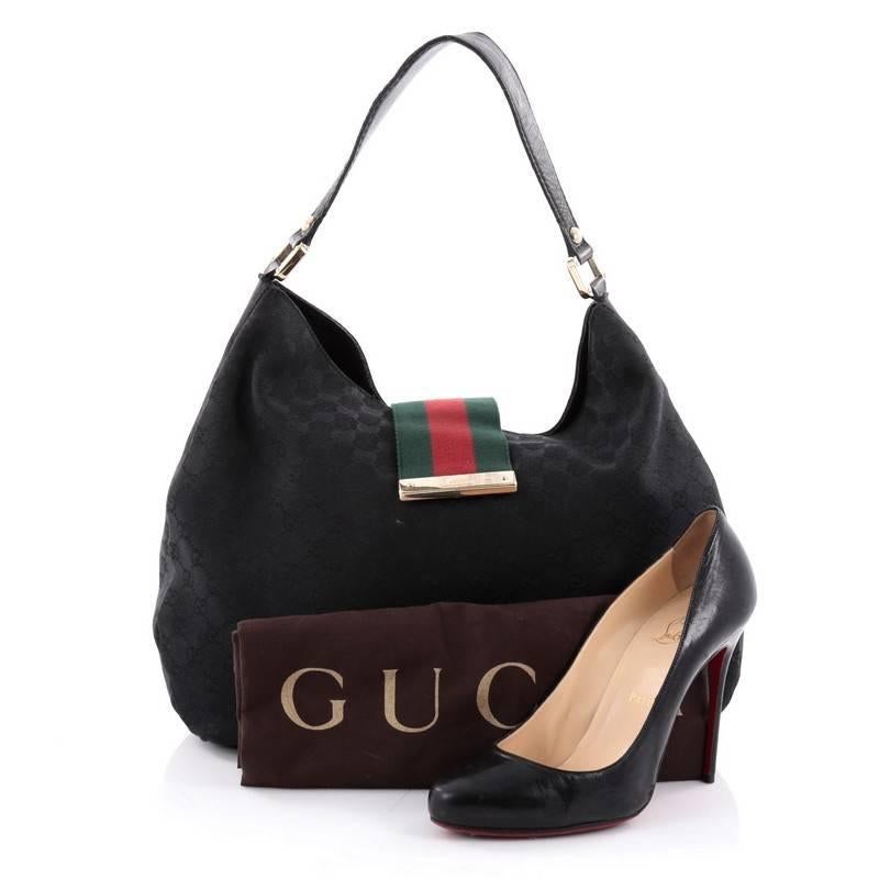 This authentic Gucci New Ladies Web Hobo GG Canvas Large is classic and sophisticated bag perfect for everyday use. Crafted in black GG canvas, this hobo features black leather trims, single loop shoulder strap, signature green and red striped web