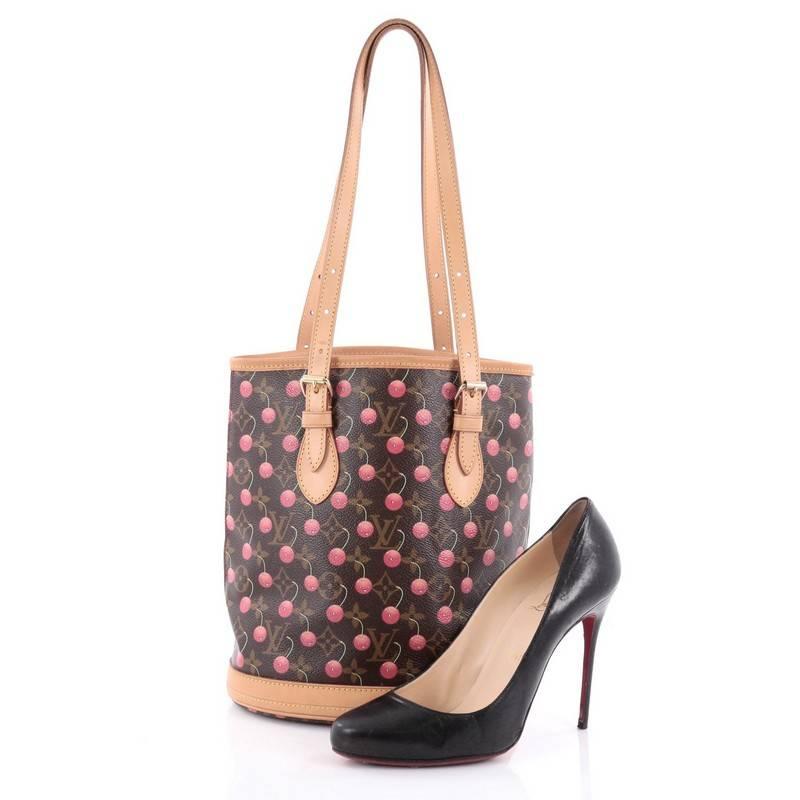 This authentic Louis Vuitton Bucket Bag Limited Edition Cerises designed by famed Japanese artist Takashi Murakami, puts a fun twist to the classic bucket bag. Crafted from brown monogram coated canvas adorned with bright cheerful cherries, this