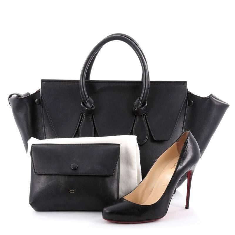This authentic Celine Tie Knot Tote Smooth Leather Small is an absolute must-have for modern fashionistas. Crafted from black smooth leather, this boxy, chic tote features dual-rolled leather handles with signature knot accents, protective base