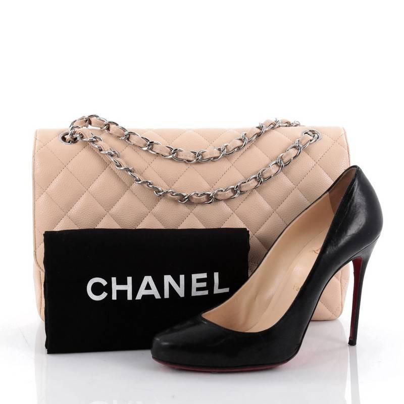 This authentic Chanel Classic Double Flap Bag Quilted Caviar Jumbo exudes a classic yet easy style made for the modern woman. Crafted from beige caviar leather, this elegant flap features Chanel's signature diamond quilted design, woven-in leather