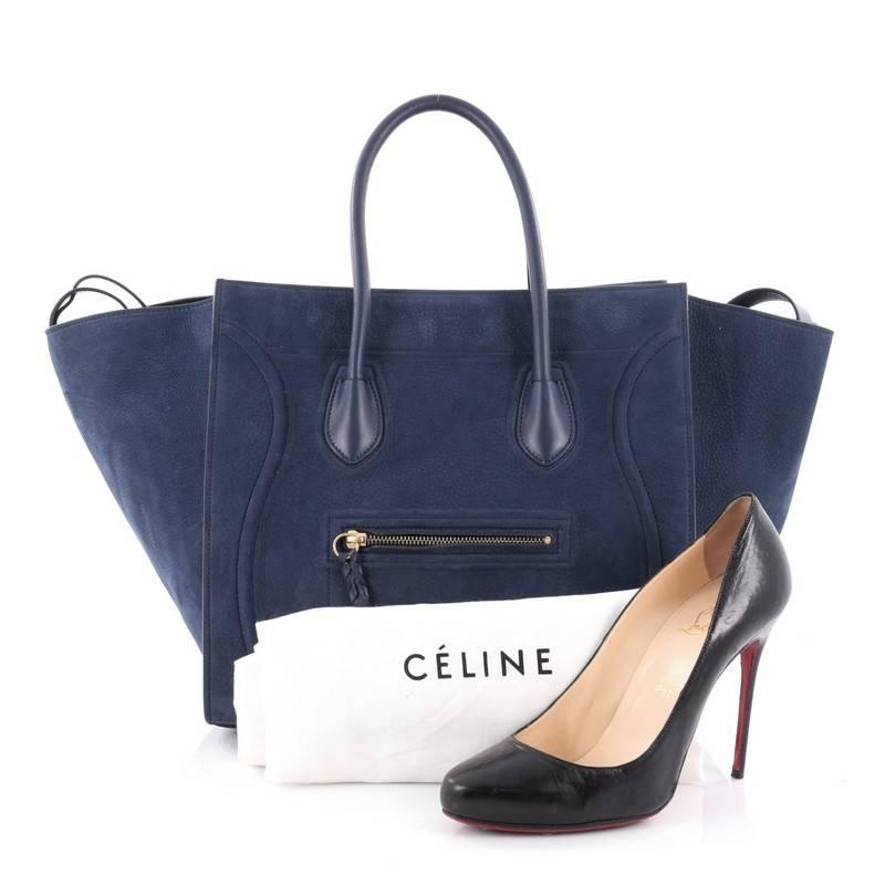 This authentic Celine Phantom Handbag Suede Medium is one of the most sought-after bags beloved by fashionistas. Crafted from blue suede, this minimalist tote features dual-rolled handles, an exterior front pocket, protective base studs, stamped