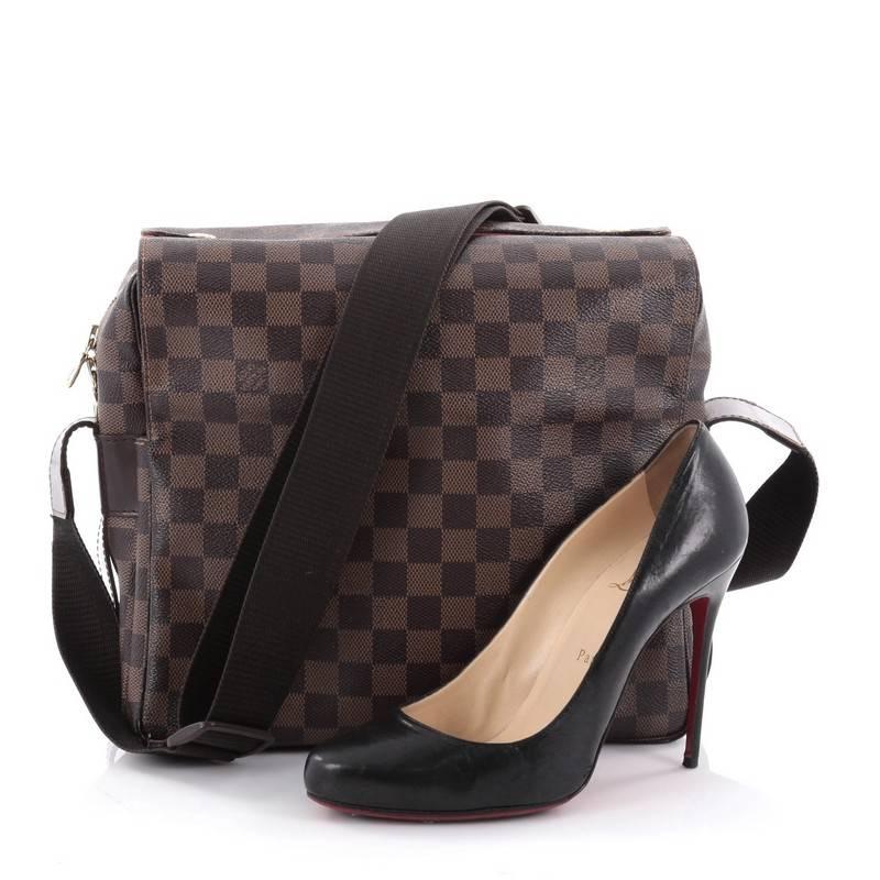 This authentic Louis Vuitton Naviglio Handbag Damier is perfect for the style-conscious man or woman on the go. Crafted from brown ebene coated canvas, this elegant bag features wide canvas adjustable strap, large dual flap design, and gold-tone