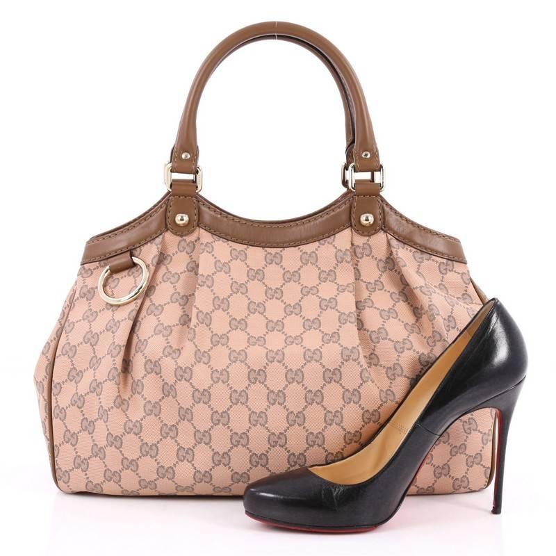 This authentic Gucci Sukey Tote GG Canvas Medium is perfect for any casual or sophisticated outfit. Constructed from Gucci's light pink and gray GG monogram canvas with brown leather trims, this roomy tote features dual-rolled leather handles that