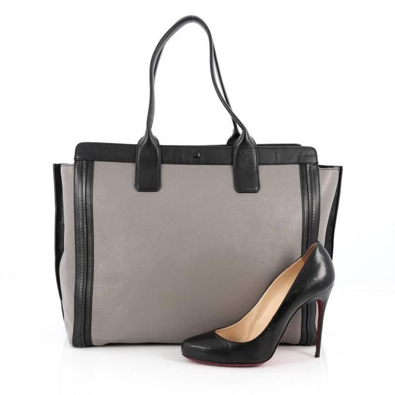 This authentic Chloe Alison East West Tote Leather Medium is a perfect everyday bag. Crafted from grey leather with black leather trims, this tote features a winged silhouette, dual tall flat handles, subtle stamped Chloe name, and gold-tone