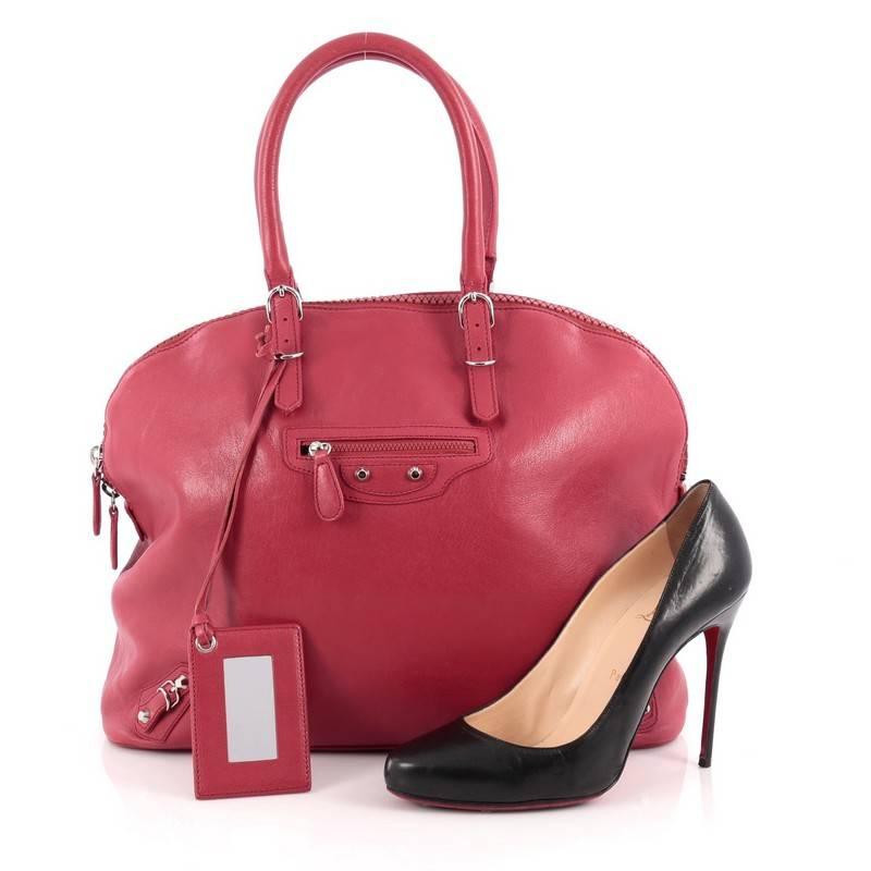 This authentic Balenciaga Carousel Bowling Bag Classic Studs Leather Large is a chic bag with bold style. Constructed in red leather, this bowling bag features a rounder silhouette, dual-rolled leather handles, zipped front pocket, the brand's