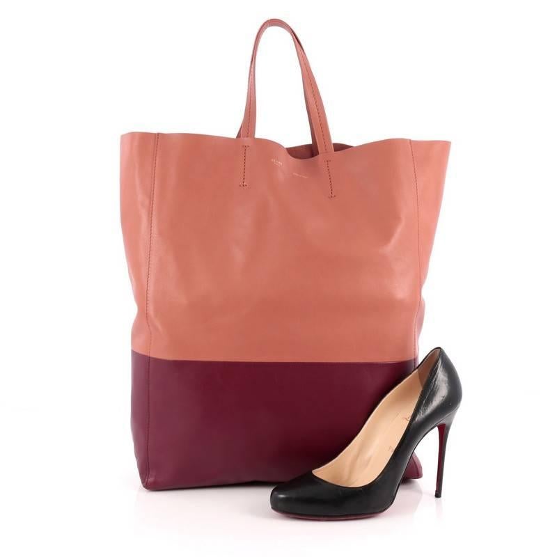 This authentic Celine Vertical Bi-Cabas Tote Leather Large is a perfect everyday accessory for the woman on-the-go. Crafted in minimalist bi-color salmon and wine leather, this no-fuss tall tote features slim top handles and gold-tone hardware