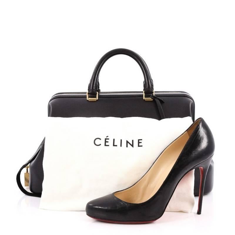 This authentic Celine Frame Doctor Bag Leather Medium is a hard-to-find sophisticated bag that mixes subtle elegance and quiet luxury made for the modern fashionista. Crafted in black leather, this doctor bag features a framed top, dual-rolled