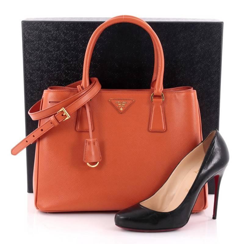 This authentic Prada Lux Convertible Open Tote Saffiano Leather Small is elegant in its simplicity and structure. Crafted from papaya orange saffiano leather, this sturdy and spacious tote features dual-rolled handles, iconic inverted Prada triangle