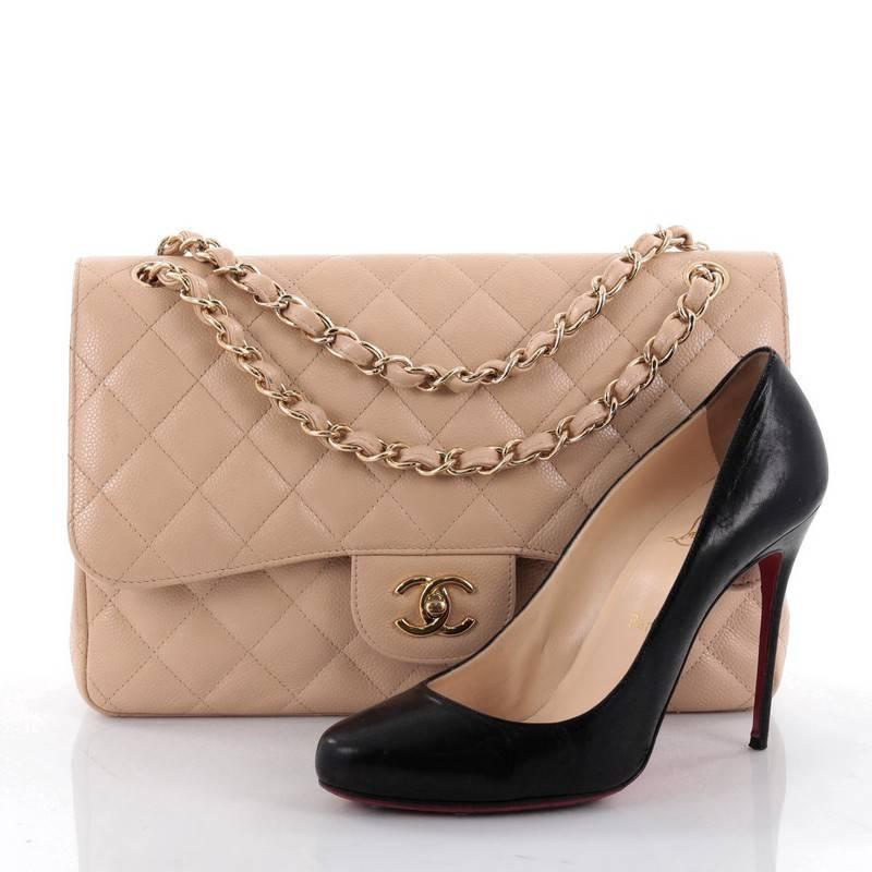 This authentic Chanel Classic Double Flap Bag Quilted Caviar Jumbo exudes a classic yet easy style made for the modern woman. Crafted from nude caviar leather, this elegant flap features Chanel's signature diamond quilted design, woven-in leather