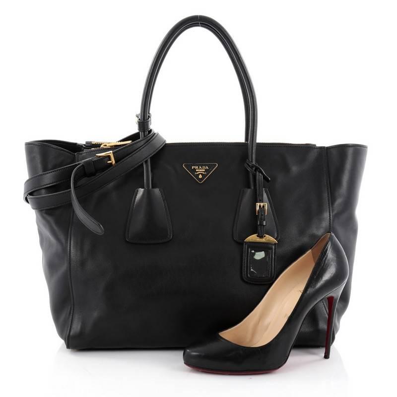 This authentic Prada Twin Pocket Tote City Calfskin Large showcases a modern silhouette perfect for today's woman. Crafted from black calfskin leather, this stylish and functional tote features dual-rolled handles, expanded winged sides, raised