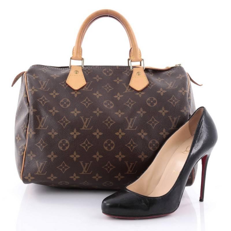 This authentic Louis Vuitton Speedy Handbag Monogram Canvas 30 is spacious and light, making it ideal to use everyday. Constructed in Louis Vuitton's classic brown monogram coated canvas, this iconic Speedy features dual-rolled leather handle,