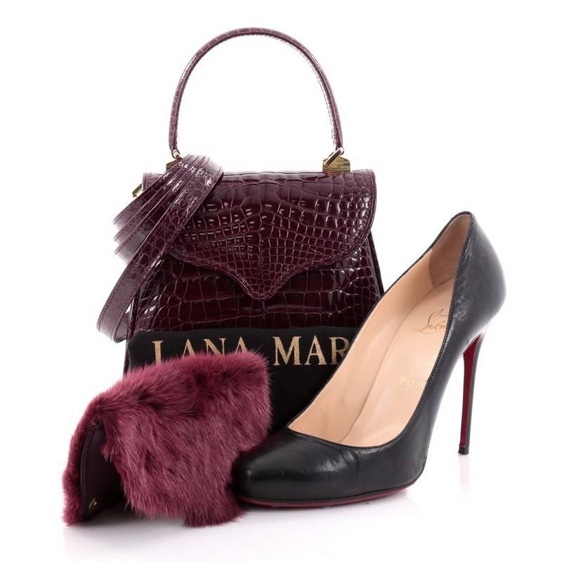 This authentic Lana Marks Princess Diana Frame Bag Alligator is an exceptionally elegant masterpiece classic to Lana Marks. Handcrafted in genuine purple alligator skin, this simple yet luxurious structured handle bag features a single looped strap,