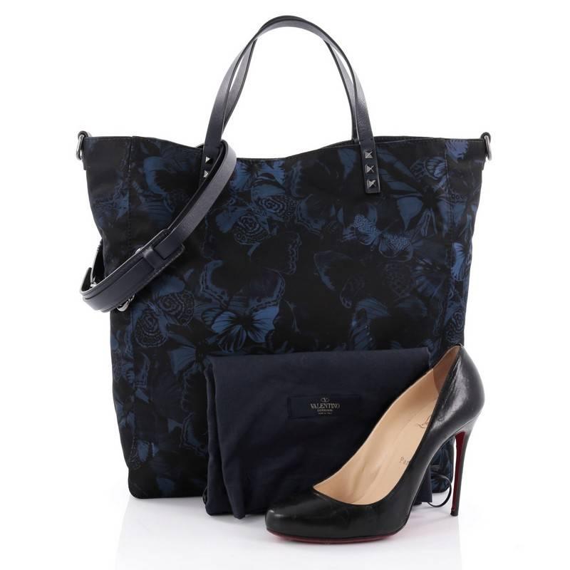 This authentic Valentino Rockstud Open Convertible Tote Butterfly Print Nylon Large is the perfect daily bag for an on-the-go fashionista. Crafted in navy blue and black butterfly print nylon, this chic, stand-out tote features the brand's iconic