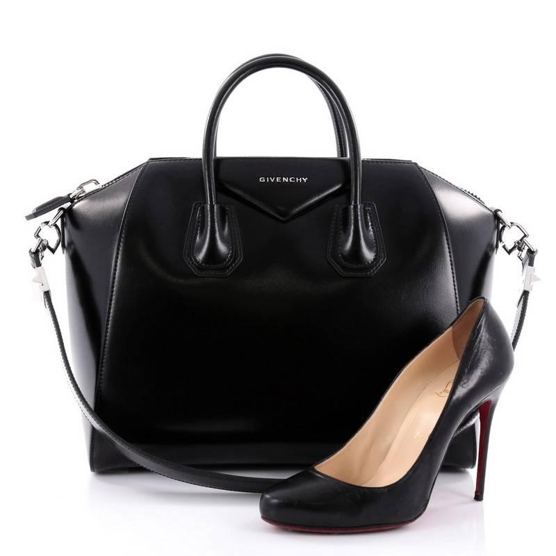 This authentic Givenchy Antigona Bag Glazed Leather Medium is a go-to fashionista favorite. Constructed in black glazed leather, this structured yet stylish tote features Givenchy's signature envelope fold logo in front, dual top handles and