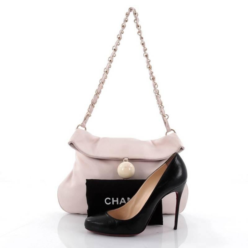 This authentic Chanel Cue Ball Foldover Bag Leather Medium is a wonderfully crafted feminine bag perfect for everyday use. Crafted from pale pink leather, this chic and stylish bag features, a loose flap silhouette, woven-in leather chain-link